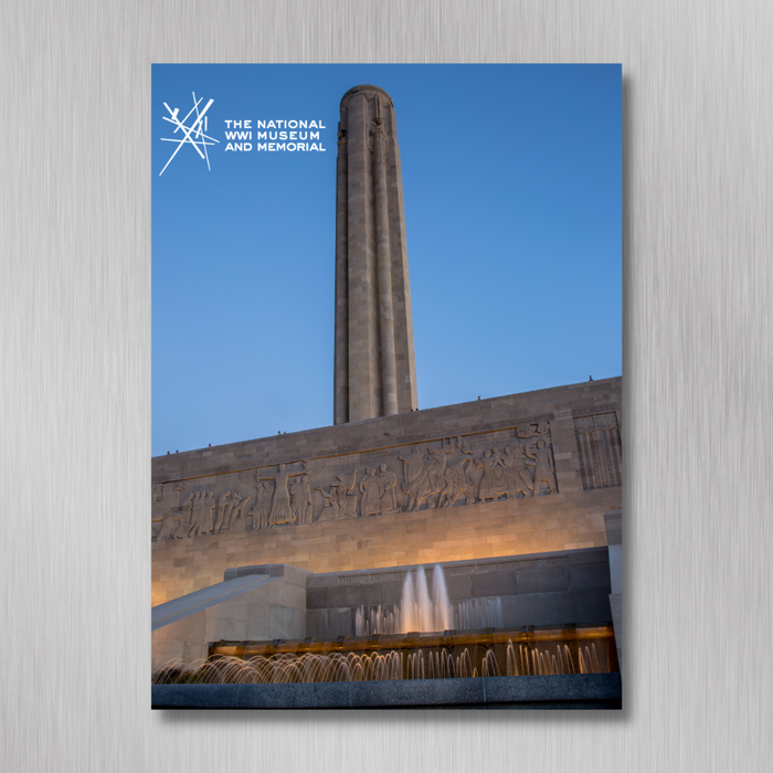 The image shows the Liberty Memorial tower at the National WWI Museum and Memorial, featuring a stone facade with carvings by WWI veteran Edmond Amateis and a fountain below, set against a clear blue sky.