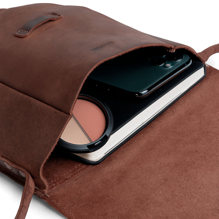 The Prisma Shoulder Bag by Hide & Drink, open to reveal its spacious interior. This vintage purse is designed as a versatile messenger and crossbody bag, made from luxurious full grain leather. Reflecting small batch production, it's hand cut and hand sewn by artisans in La Antigua Guatemala & Oaxaca Mexico.