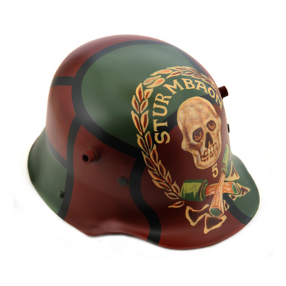 A replica 1916 German Sturmbaon Stahlhelm helmet with a green and red camouflage pattern and skull emblem featuring crossed bones, a wreath, and the text STURMBAON 5.