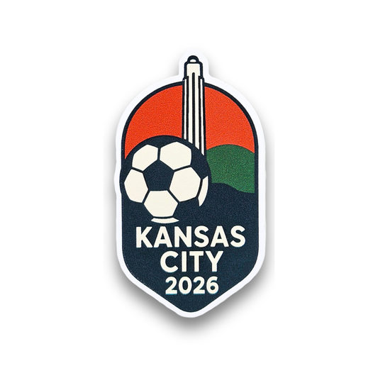 A red, green, and dark blue sticker that has a graphic of a soccer ball with the Liberty Memorial Tower in the background. Near the bottom is text that reads 'Kansas CIty 2026'.